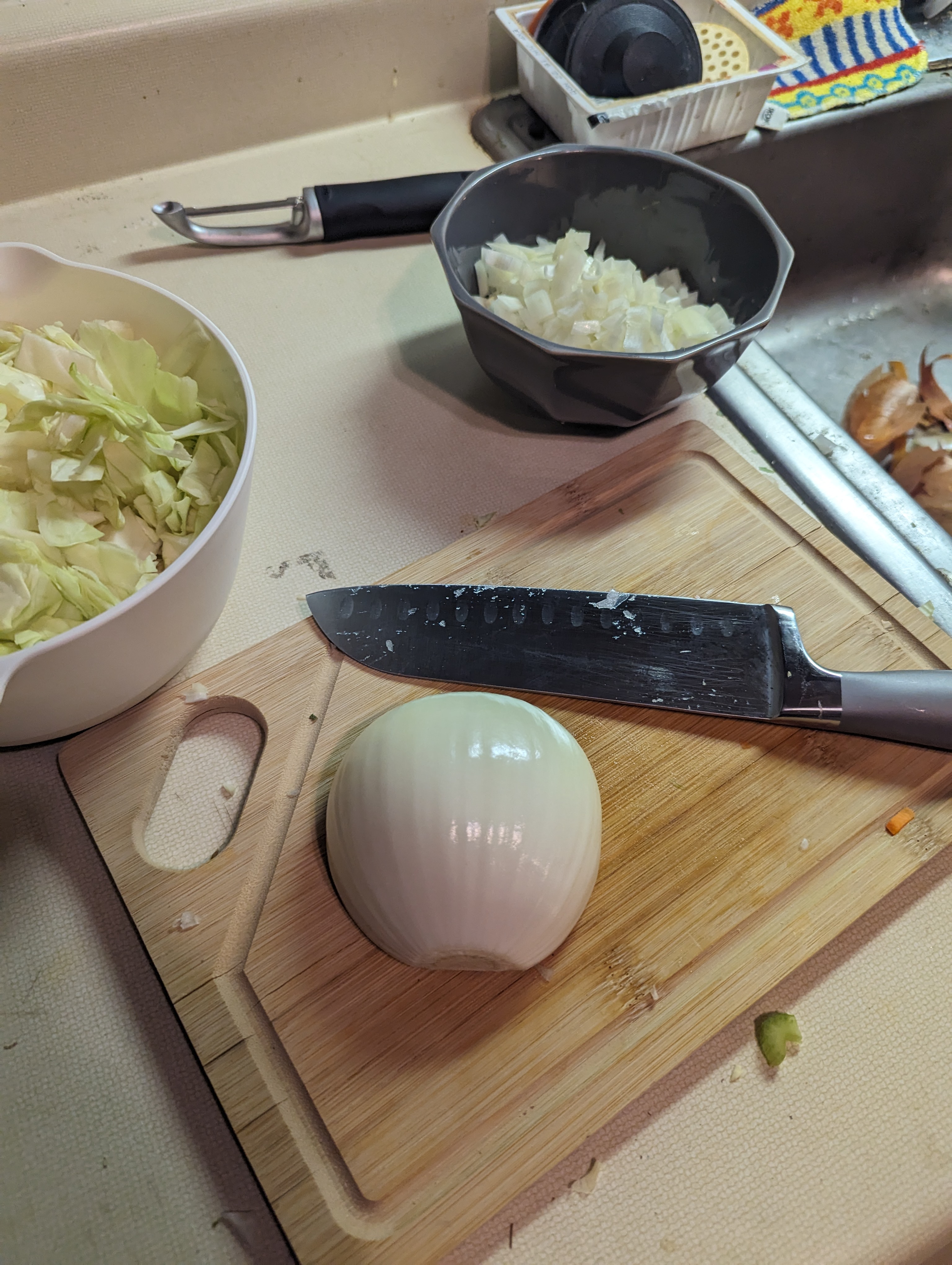 A yellow onion, half-way through being chopped